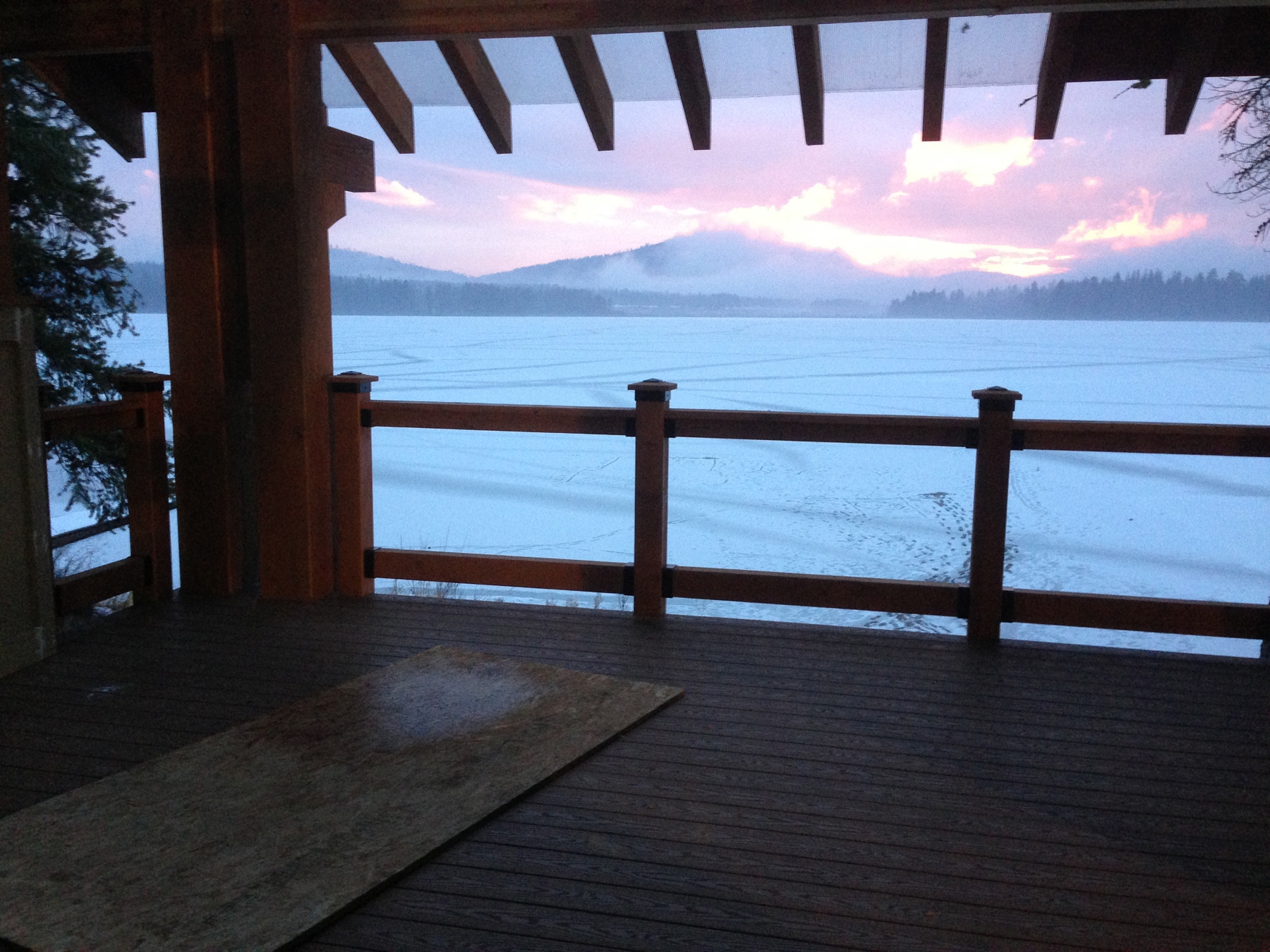 Deck overlooking river and sunset sky.