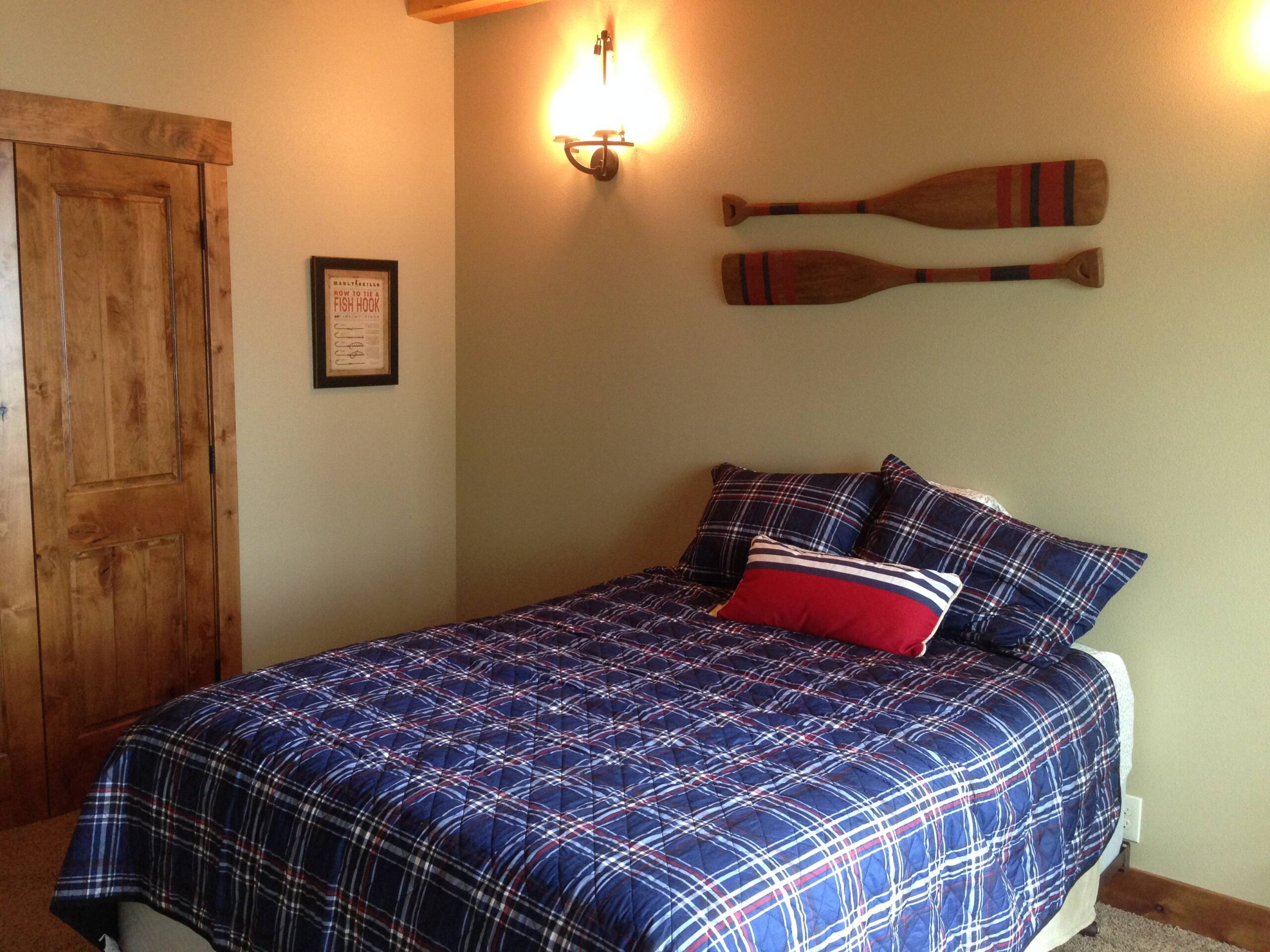 Bedroom with double bed and wall-mounted oar.